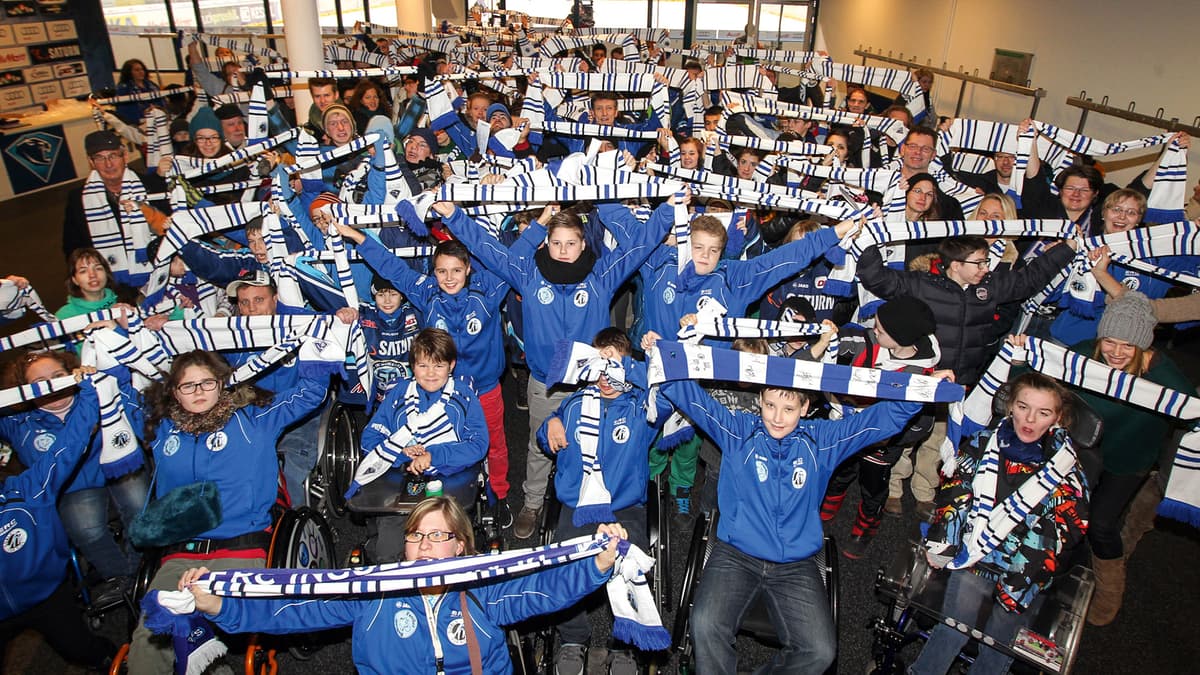 Kinder, die ihre Fußball-Schale in die Luft halten